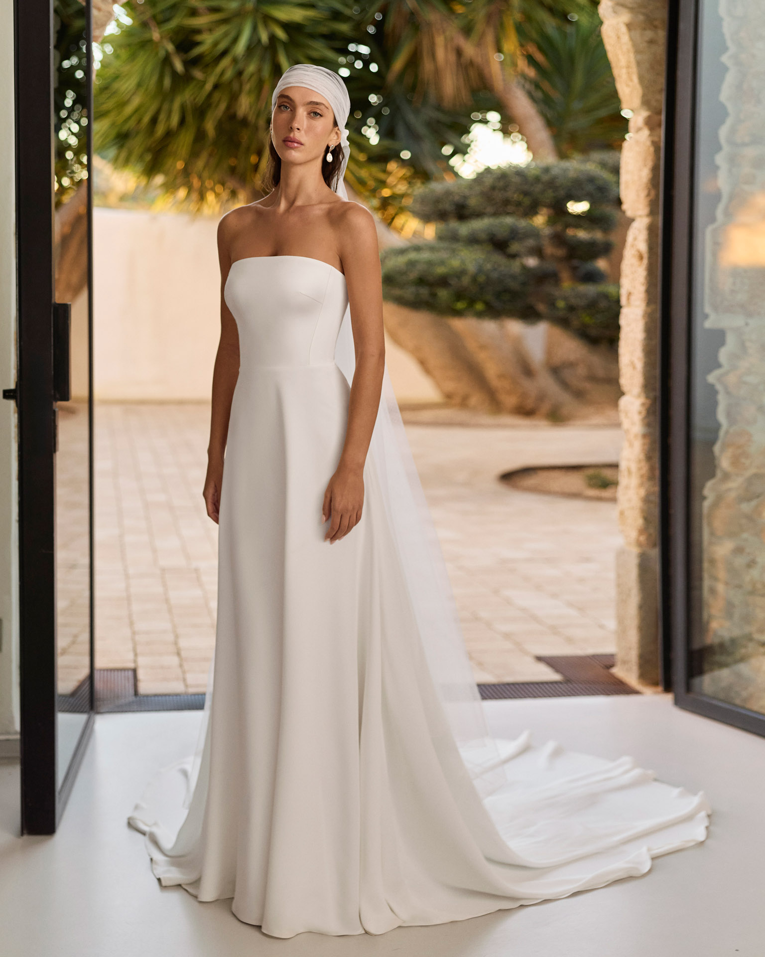 Vestido de novia Relia de Aire Barcelona 2027 con mangas largas de gasa transparente, escote barco, cintura de encaje, falda fluida de crepé y elegante espalda cerrada.