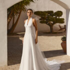 Vestido de novia Renys de Aire Barcelona 2027 en crepé con escote halter, espalda descubierta, cintura bordada y falda de caída fluida.