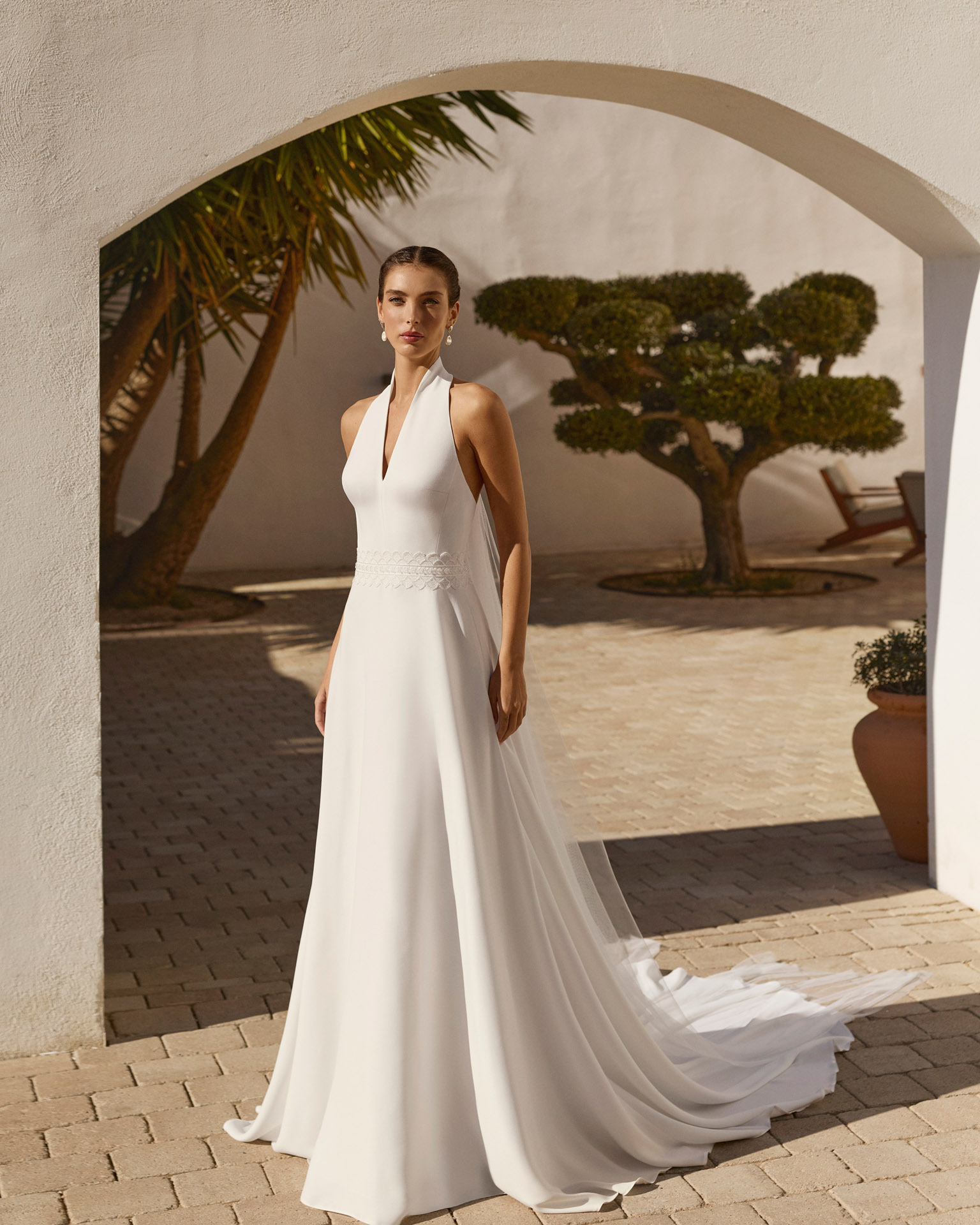 renys-vestido-novia-halter-crepe-aire-barcelona-2027.frente Vestido de novia Renys de Aire Barcelona 2027 en crepé con escote halter, espalda descubierta, cintura bordada y falda de caída fluida.