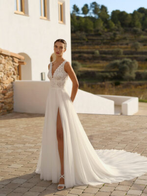 Vestido de novia Rin de Aire Barcelona 2027 de línea A con cuerpo de encaje floral, escote en V, espalda abierta, falda plisada de tul con abertura lateral y cola ligera.