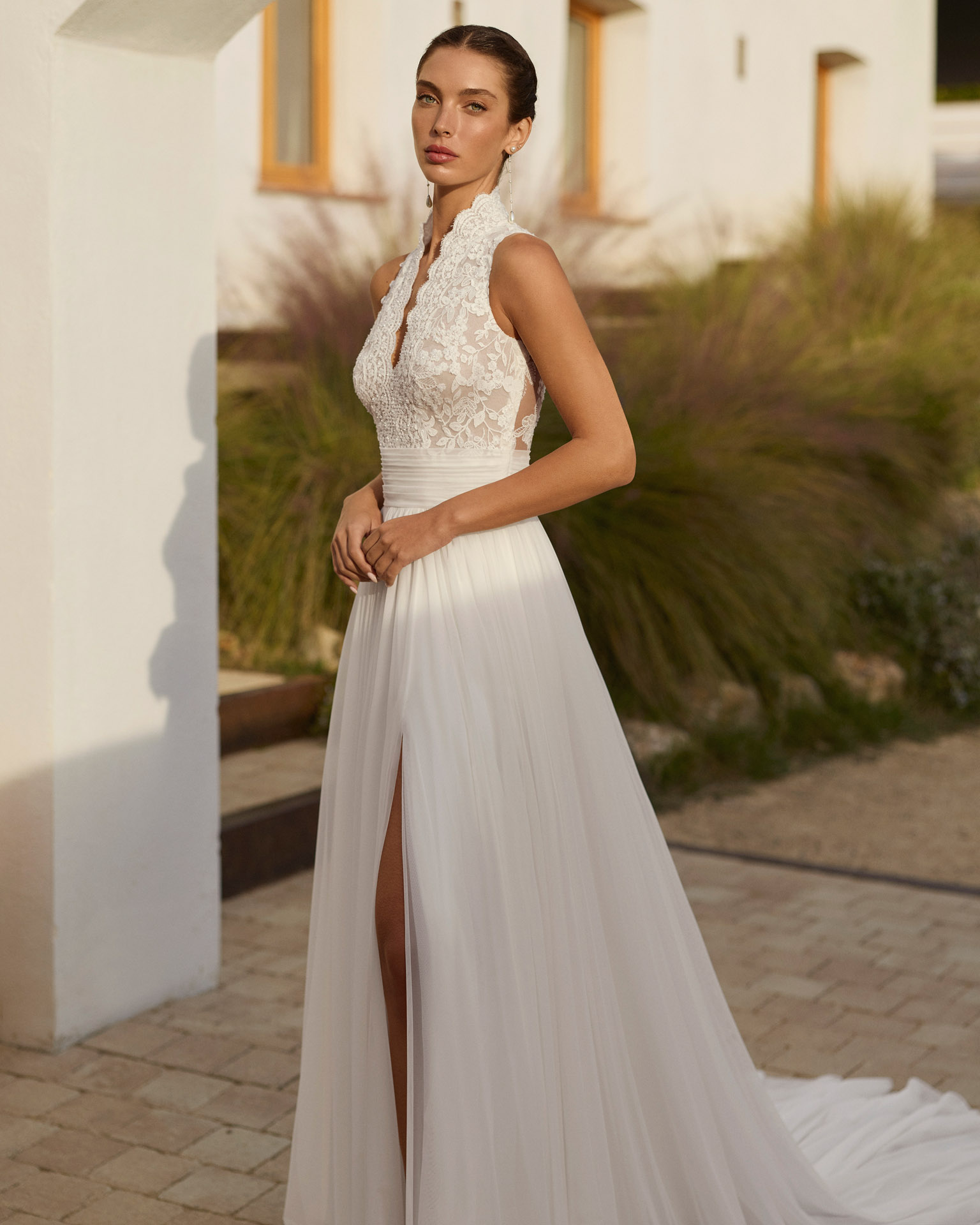 Vestido de novia Rinlo de Aire Barcelona 2027 de corte A en gasa plisada con escote halter de encaje, cuerpo semitransparente, abertura en la falda y espalda de encaje.