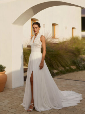 Vestido de novia Rinlo de Aire Barcelona 2027 de corte A en gasa plisada con escote halter de encaje, cuerpo semitransparente, abertura en la falda y espalda de encaje.