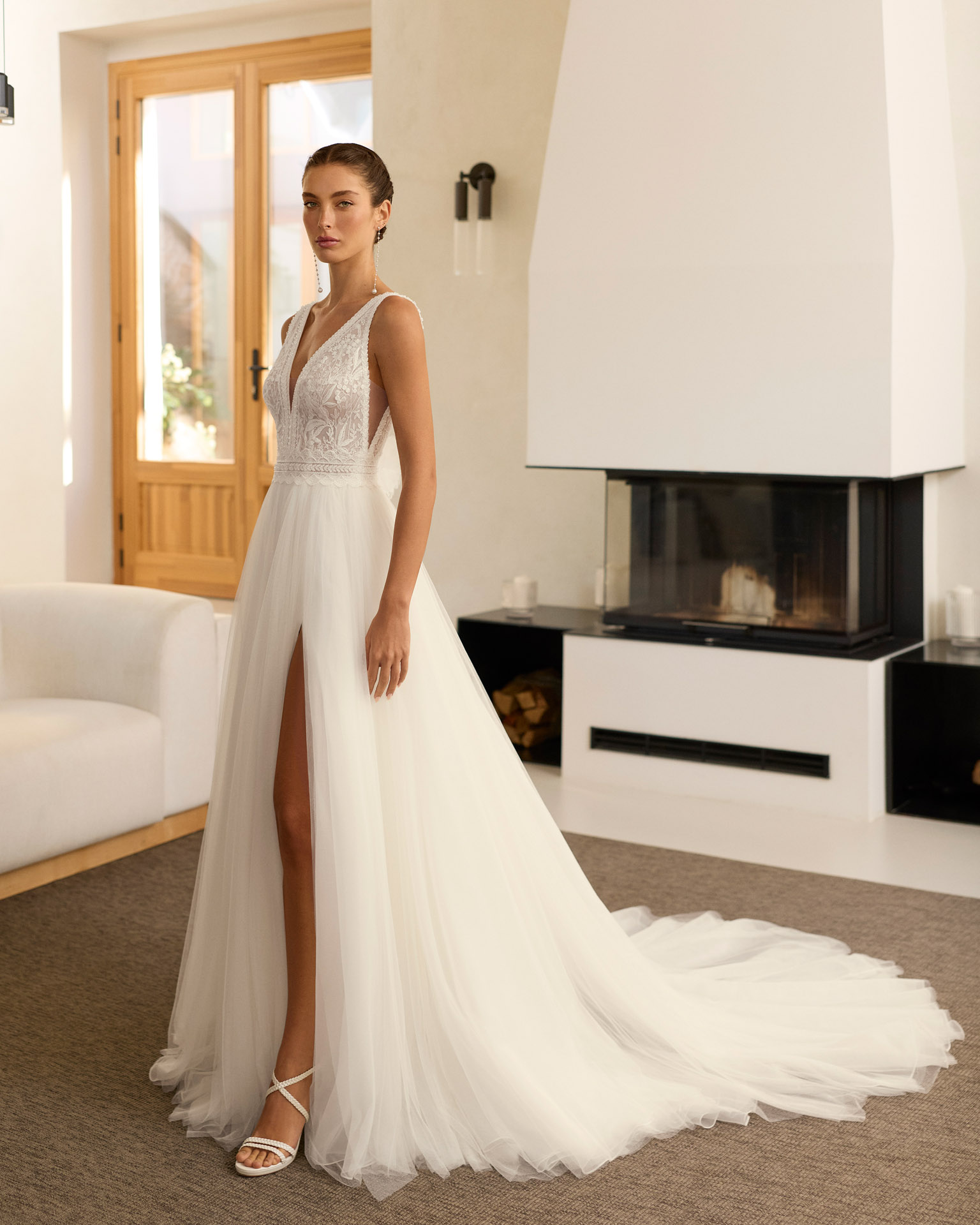 riosa-vestido-novia-corte-a-tul-escote-pico-aire-barcelona-2027.delante (2) Vestido de novia Riosa de Aire Barcelona 2027 de corte A en tul con escote en pico, cuerpo de encaje floral, espalda en V, abertura frontal y detalle floral en la espalda.