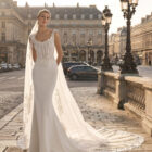 Vestido de novia Teline de Aire Barcelona 2027 de corte sirena en crepé, cuerpo de encaje bordado, escote redondeado y elegante cola de tul con aplicaciones florales.