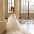Vestido de novia Aire Barcelona 2027 con escote halter de encaje floral, falda de tul y silueta línea A de estilo romántico.