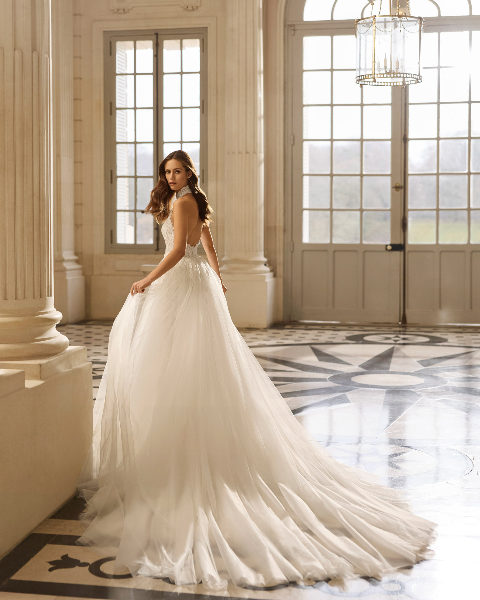 Vestido de novia Aire Barcelona 2027 con escote halter de encaje floral, falda de tul y silueta línea A de estilo romántico.