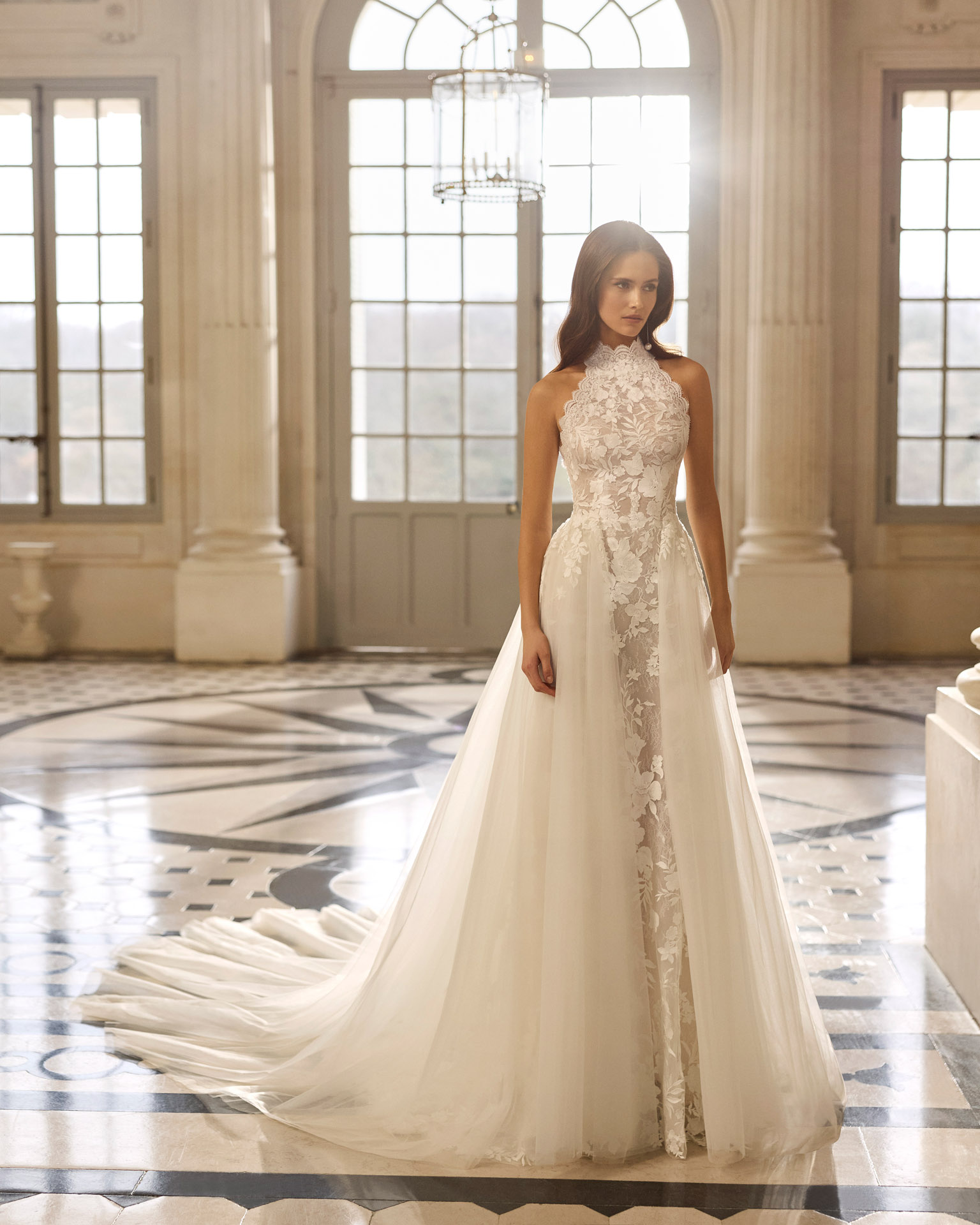 Vestido de novia Aire Barcelona 2027 con escote halter de encaje floral, falda de tul y silueta línea A de estilo romántico.