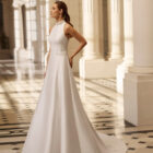 Vestido de novia Aire Barcelona 2027 de mikado con escote halter, silueta línea A y diseño minimalista de estilo elegante.