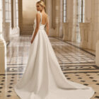 Vestido de novia Aire Barcelona 2027 de mikado con escote cuadrado, tirantes anchos, falda línea A con abertura delantera y detalle floral en la cintura. back