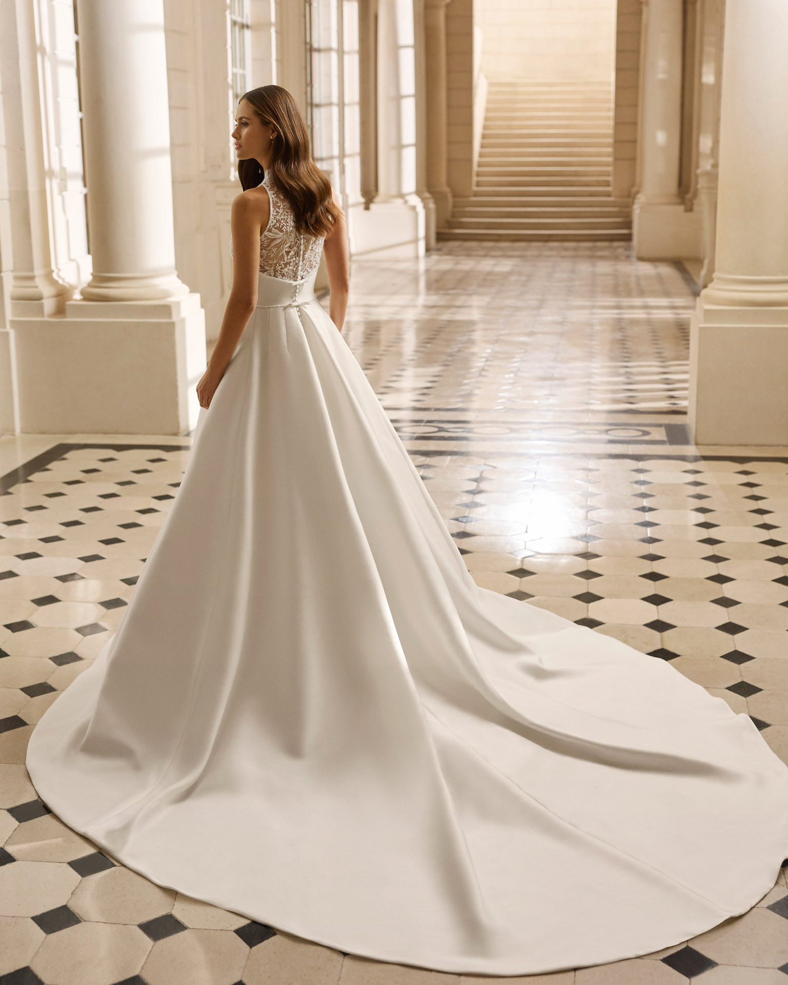 Vestido de novia Aire Barcelona 2027 de mikado con escote pico, cuerpo de encaje floral y falda evasé de estilo clásico y elegante.