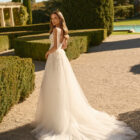 Vestido de novia Xenea de Aire Barcelona 2027 de corte A en tul bordado con escote cuadrado, cuerpo de encaje floral, abertura frontal y capa de tul integrada.