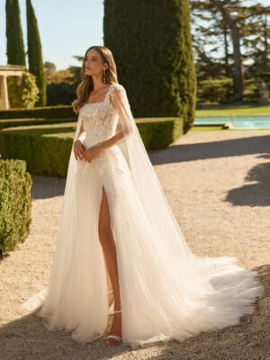 Vestido de novia Xenea de Aire Barcelona 2027 de corte A en tul bordado con escote cuadrado, cuerpo de encaje floral, abertura frontal y capa de tul integrada.
