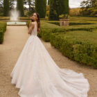 Vestido de novia Xiona de Aire Barcelona 2027 de corte princesa con escote en V, cuerpo de encaje floral, espalda descubierta y amplia falda de tul con brillo.
