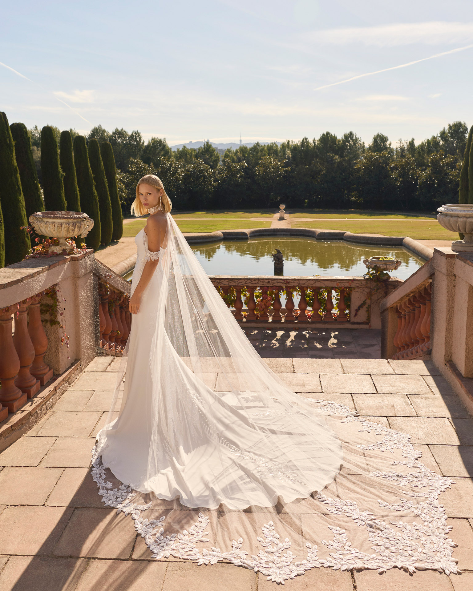 Vestido de novia Favar de Luna Novias con escote palabra de honor, encaje floral y cola de tul