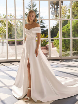 Vestido de novia Forbia de Luna Novias con escote de hombros descubiertos y falda con abertura