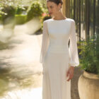 Vestido de novia Mavis de Alma Novia con manga larga, espalda drapeada y detalle floral