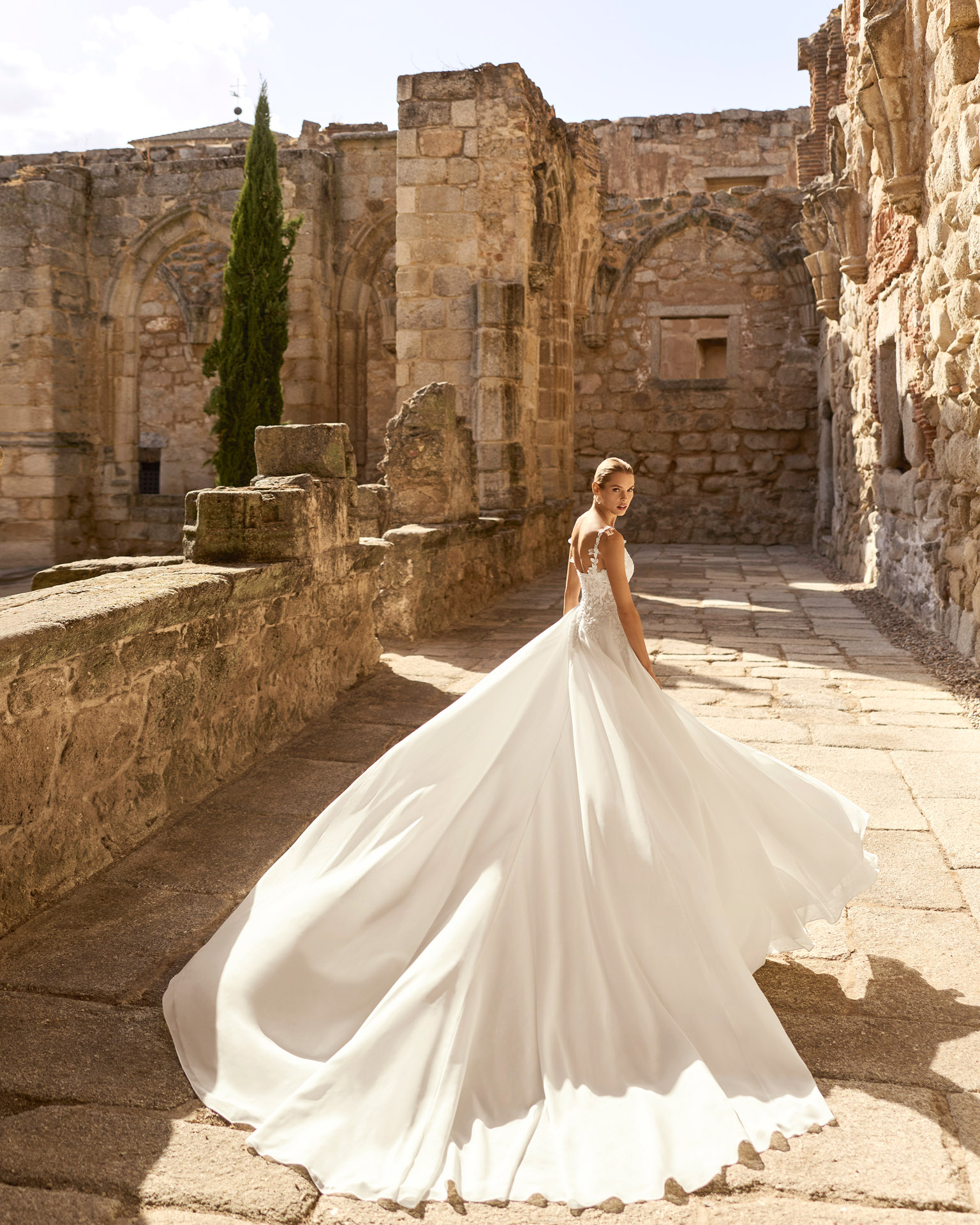 Vestido de novia Panal de Adriana Alier con cuerpo de encaje floral, escote pronunciado y falda con abertura