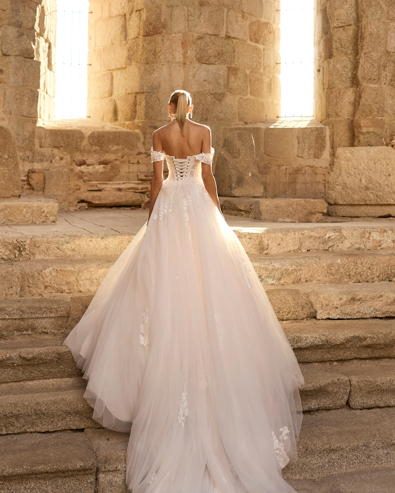 Vestido de novia Persa de Adriana Alier con corsé de encaje, hombros descubiertos y falda de tul
