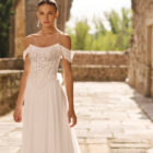 Vestido de novia Portia de Adriana Alier con corsé de encaje floral, hombros descubiertos y falda fluida